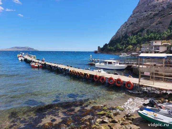 Голубое море и горы.Новый свет.Крым. Пейзаж с видом на голубое море и скалистые горы на заднем плане.