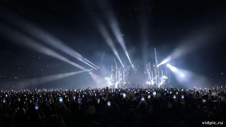 A sea of phone lights and stage beams.