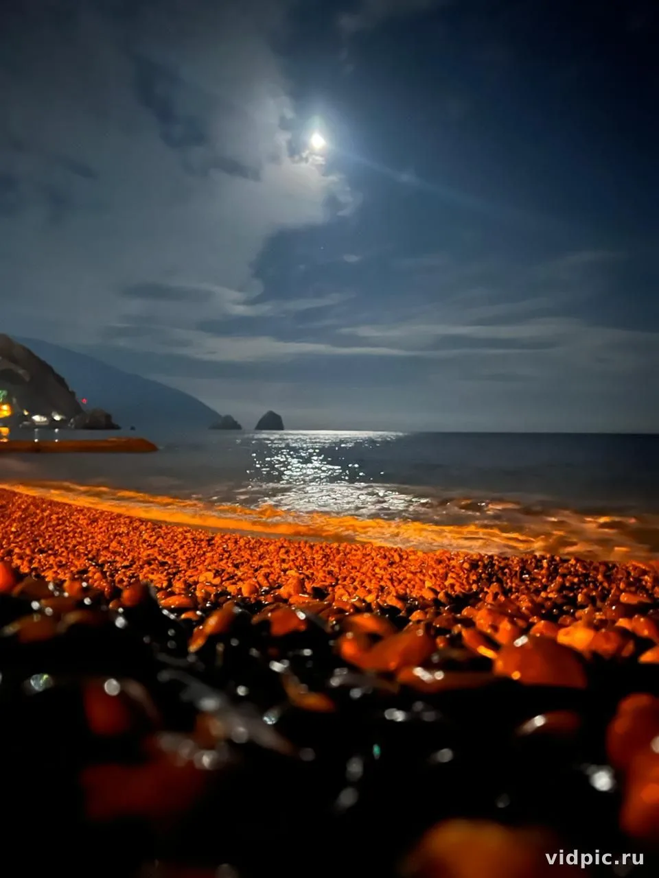 Moonlight on rocky beach. A night scene of a rocky beach illuminated by moonlight.