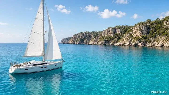 White sails on turquoise Mediterranean water.