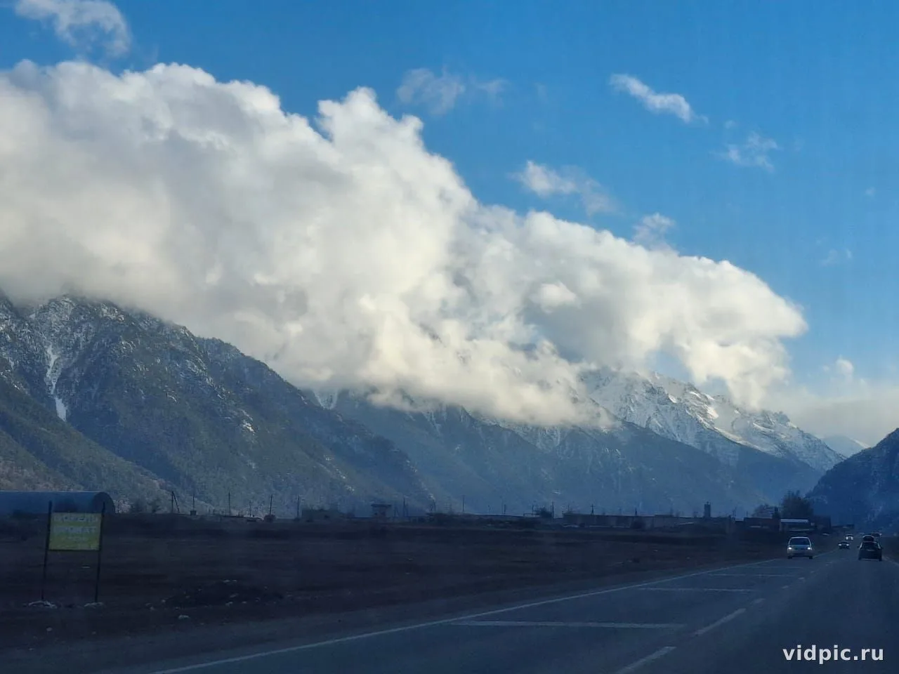 Mountain highway. A mountain highway with road markings and cars driving on it.