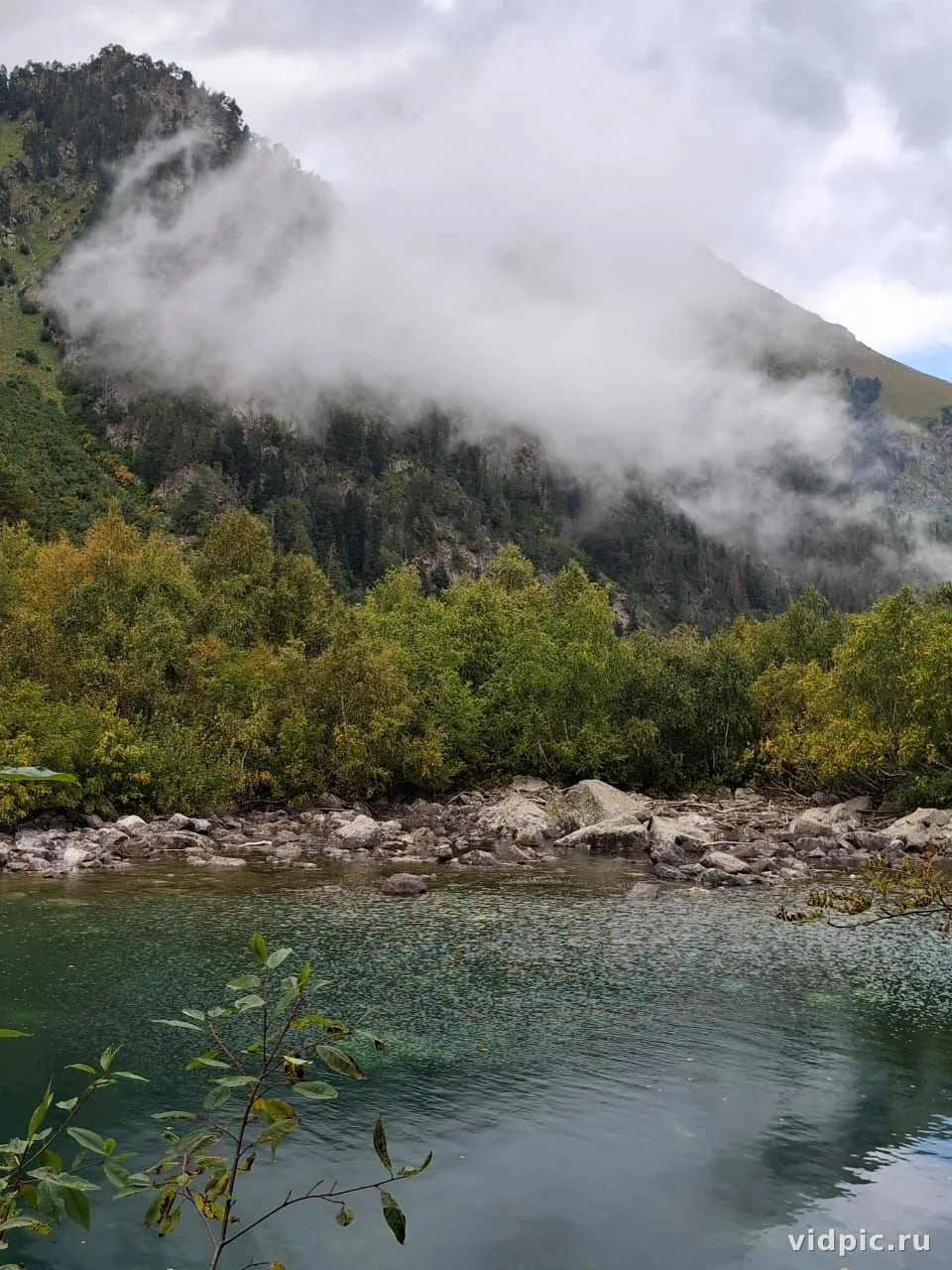 Fog over mountain lake. Fog envelops a mountain lake, creating a mystical atmosphere.