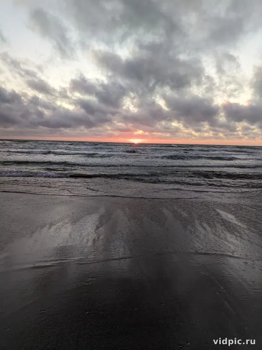 Sunset at sea with clouds. Perfect for creating a peaceful and tranquil atmosphere.