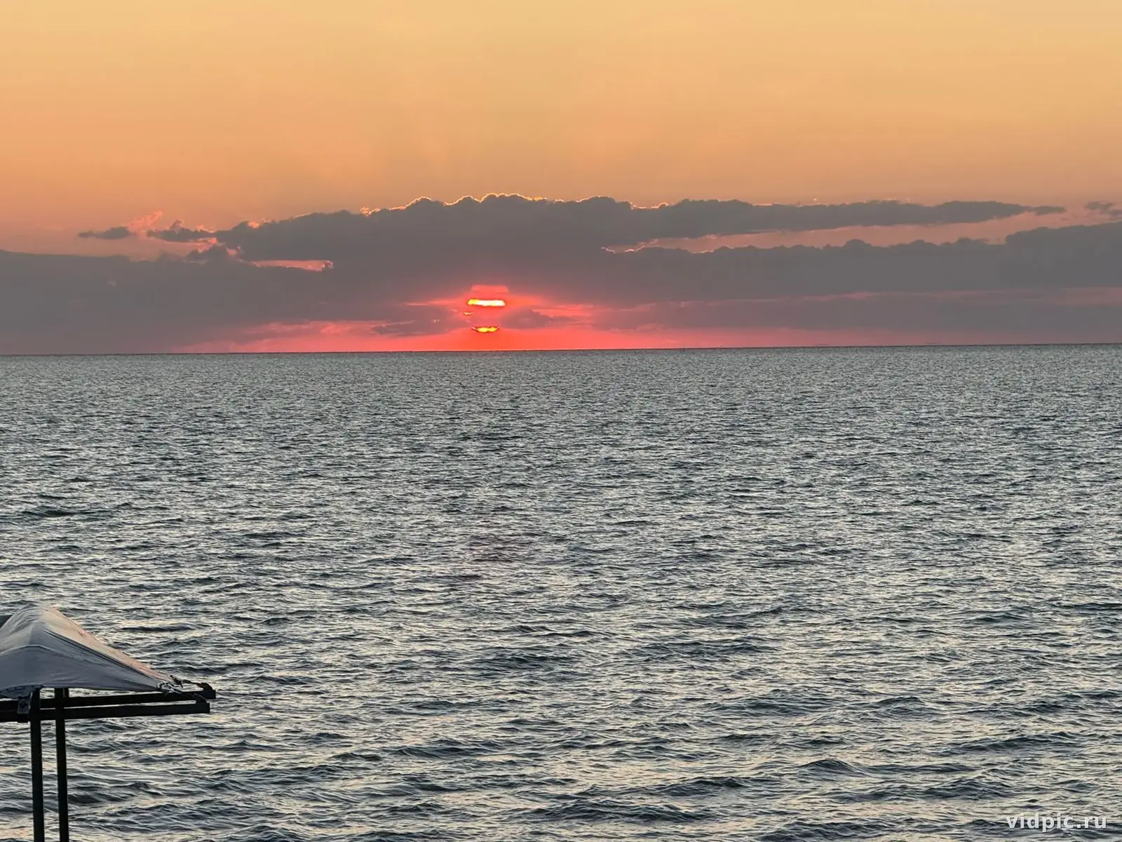 Закат над морем. Закат на море с видом на солнце, погружающееся в воду.
